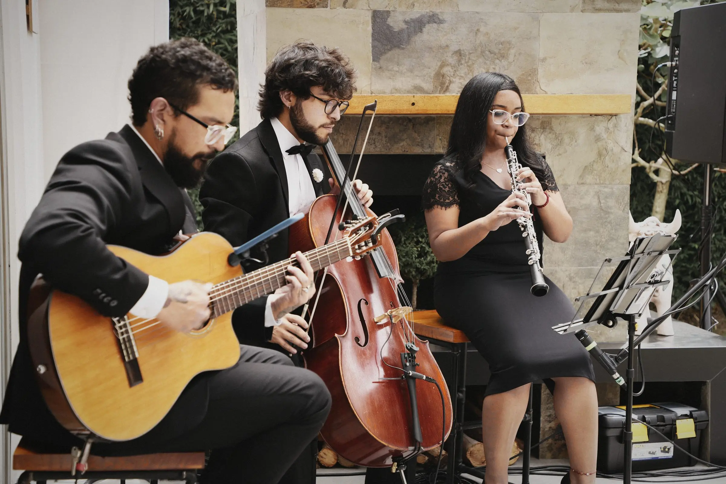 A trio playing guitar, cello and clarinet.